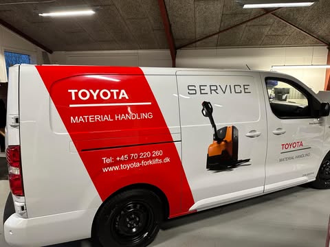 Toyota servicevogn med branding for materialehåndtering og kontaktinformation.