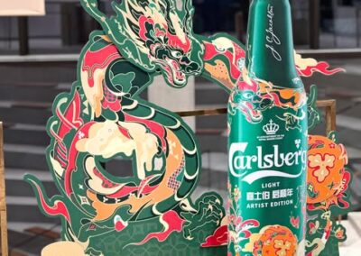Carlsberg Light flaske præsenteret med en drage og farverig dekoration i en kunstnerisk udgave.