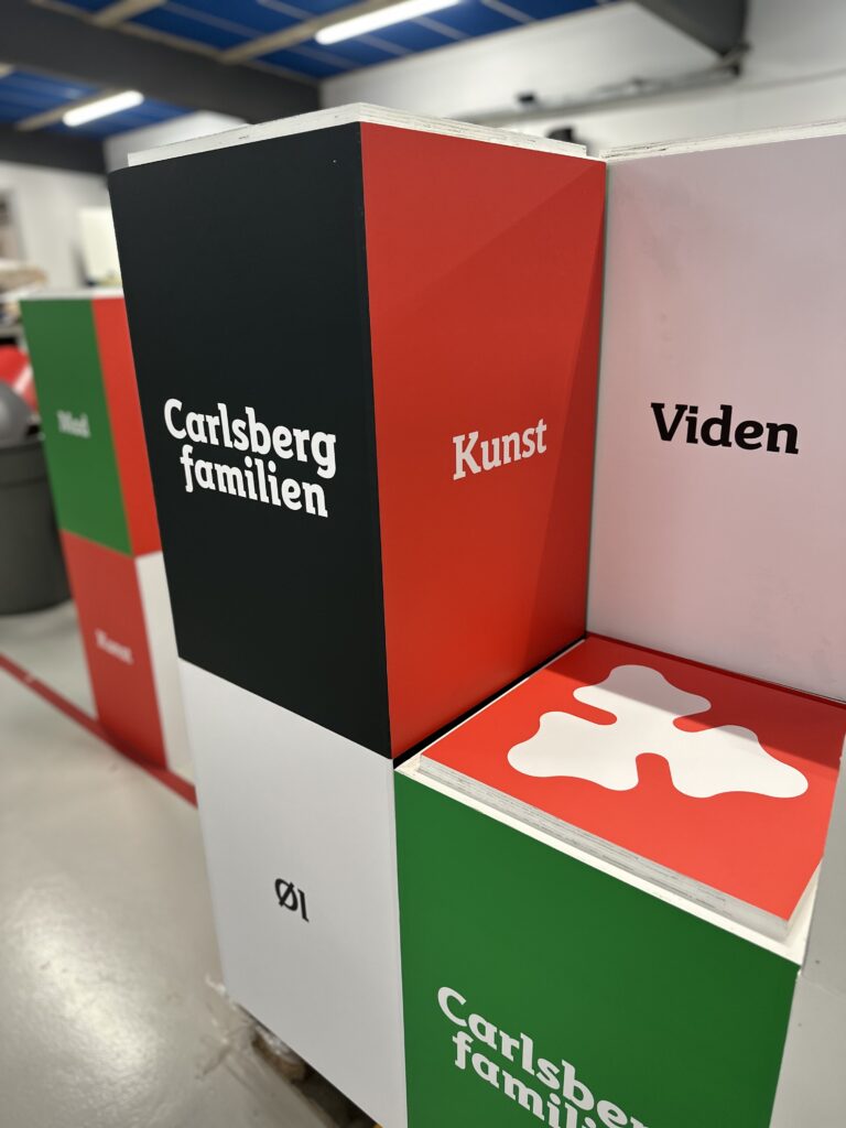 Farverig skulptur med Carlsberg familien, Kunst og Viden på forskellige sider.