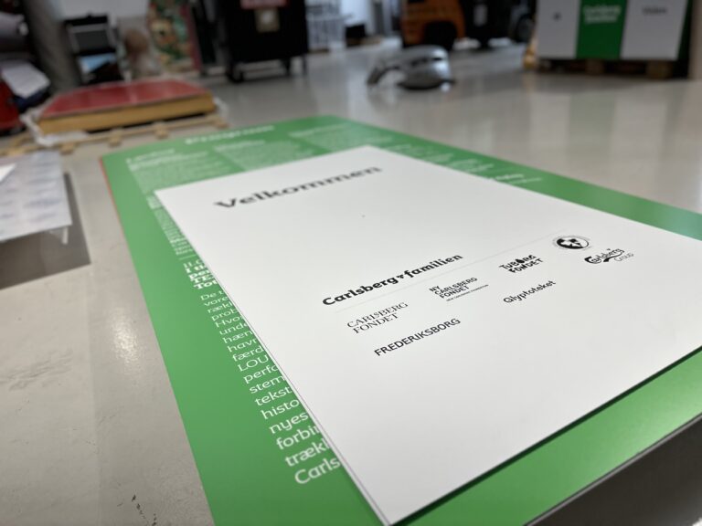 Velkomstskilt fra Carlsberg med logoer og informationer til besøgende.